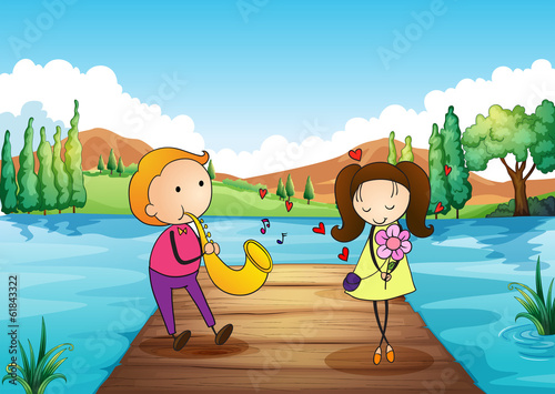 A young man serenading her girlfriend at the riverbank