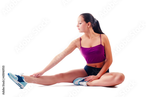 young woman in sportswear does exercises sitting on floor