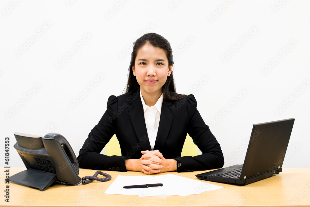 Thai business woman sitting on a desk Thai business woman sitting on a desk