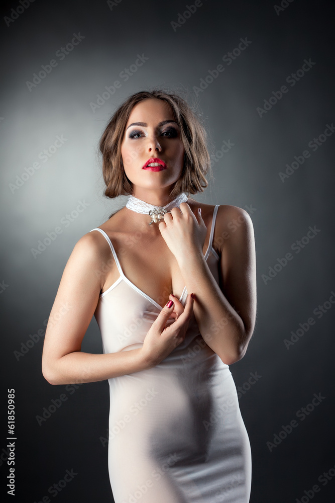 Naklejka premium Attractive sexy woman posing in white negligee