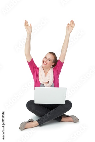 Hppy young woman with laptop raising hands © WavebreakMediaMicro