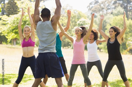 Group of fitness class exercising in park