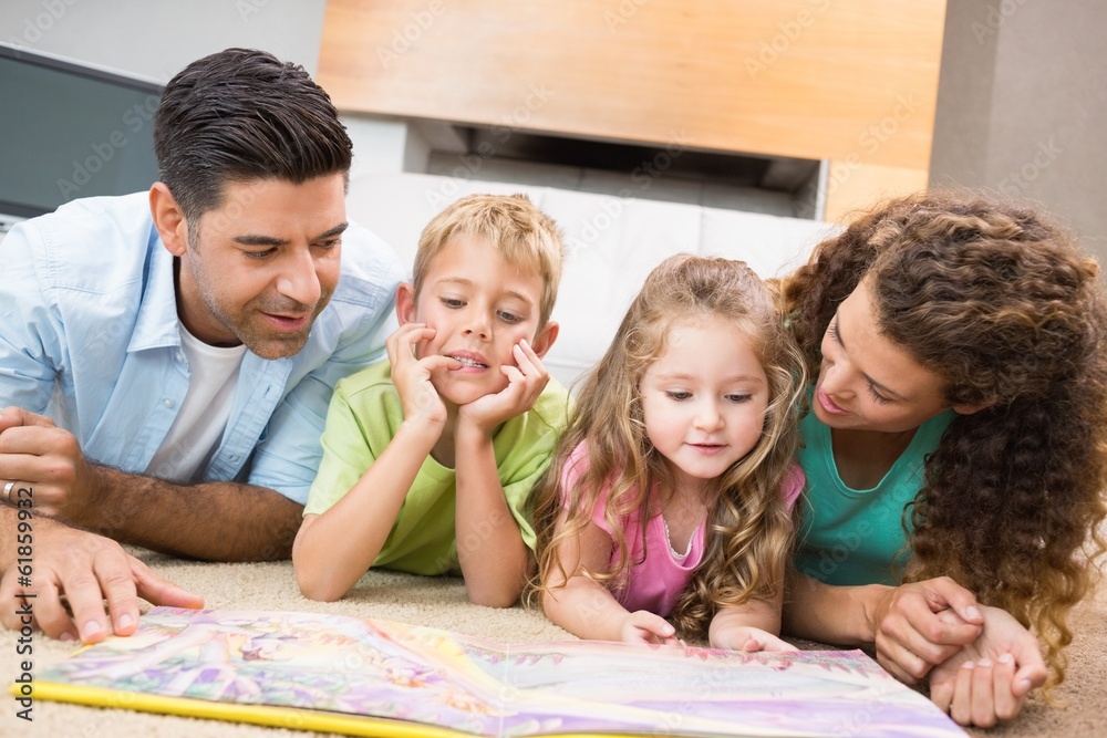 Cute siblings lying on the rug reading storybook with their Cute siblings lying on the rug reading storybook with their