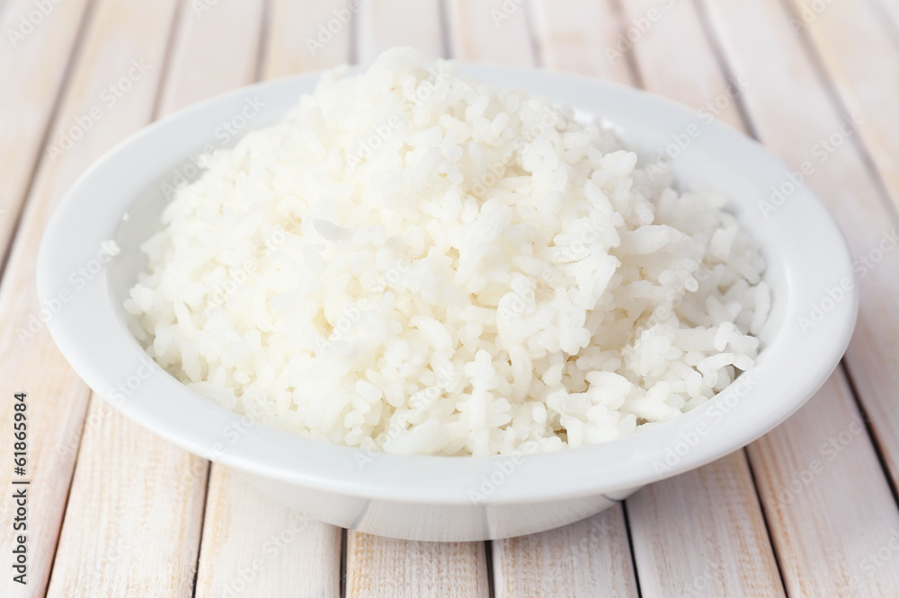 Cooked rice in bowl on wooden background Cooked rice in bowl on wooden background