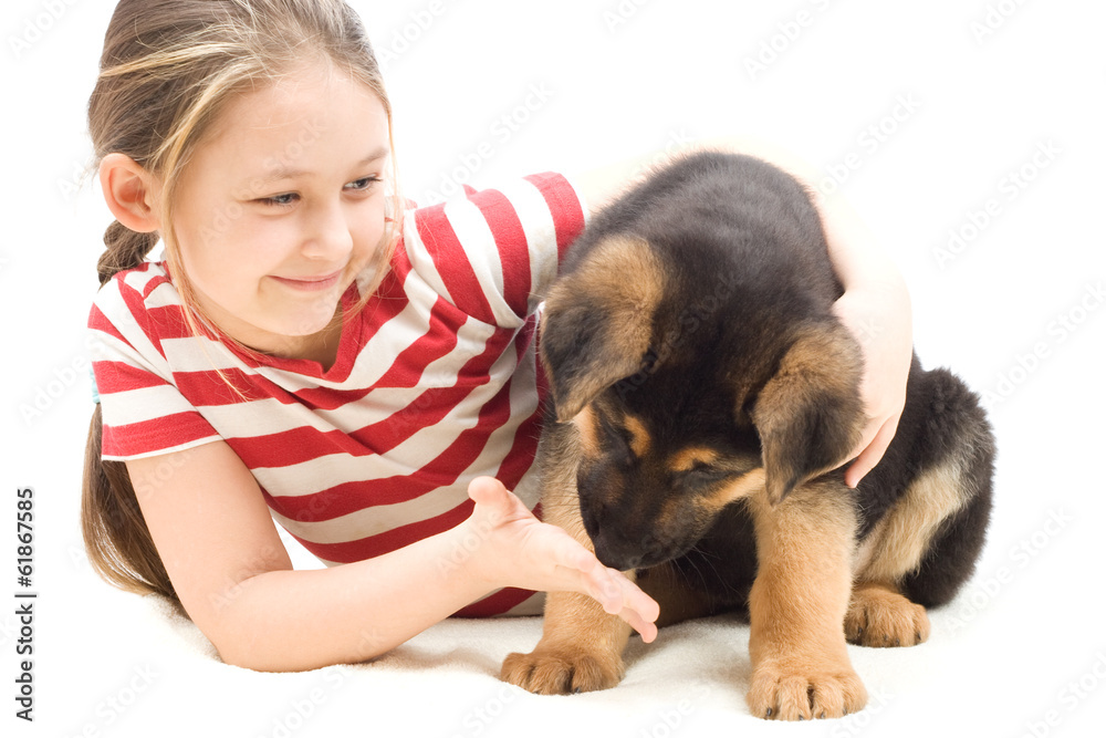 Puppy sniffs the hand of a little girl