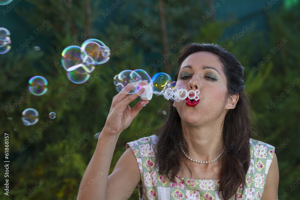 a beautiful woman blowing bubbles. spring season, rural scene a beautiful woman blowing bubbles. spring season, rural scene
