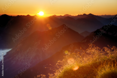 back light of sunset in mountains with warm lighted grass © A2LE
