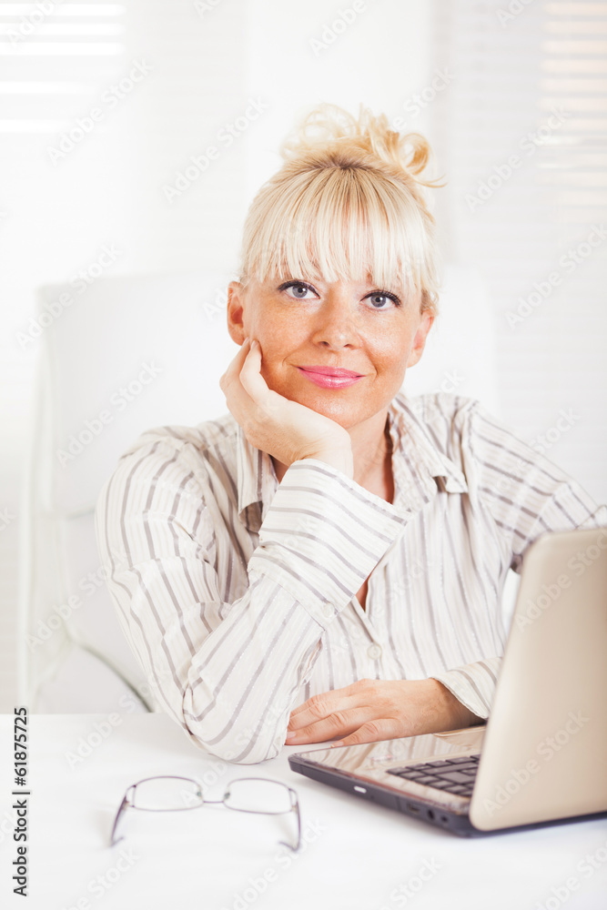 Business woman sitting in the office with laptop. Business woman sitting in the office with laptop.