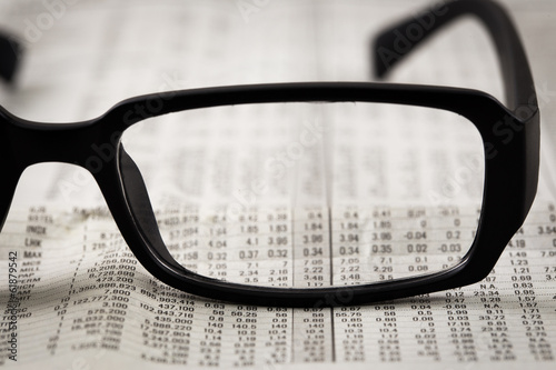 closeup glasses on financial newspaper