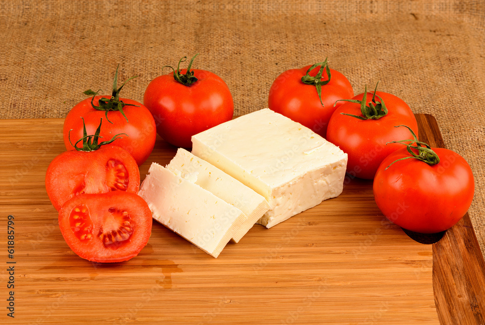 cheese and tomatoes on a cutting board cheese and tomatoes on a cutting board