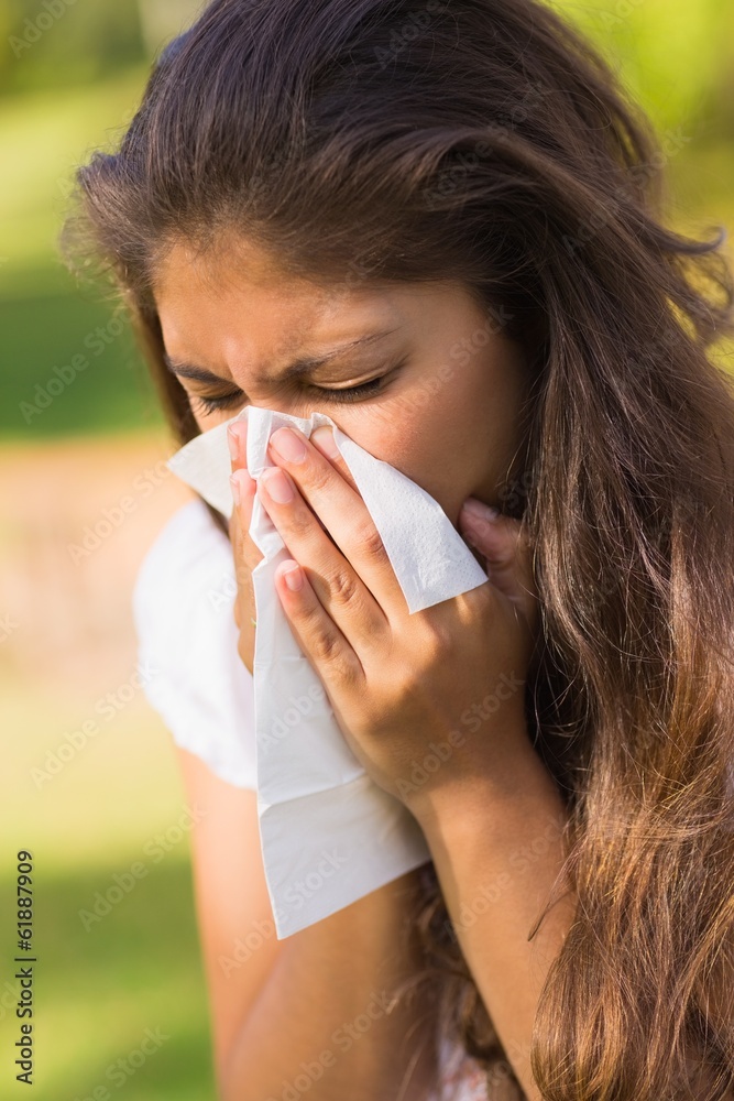 Woman blowing nose with tissue paper Woman blowing nose with tissue paper