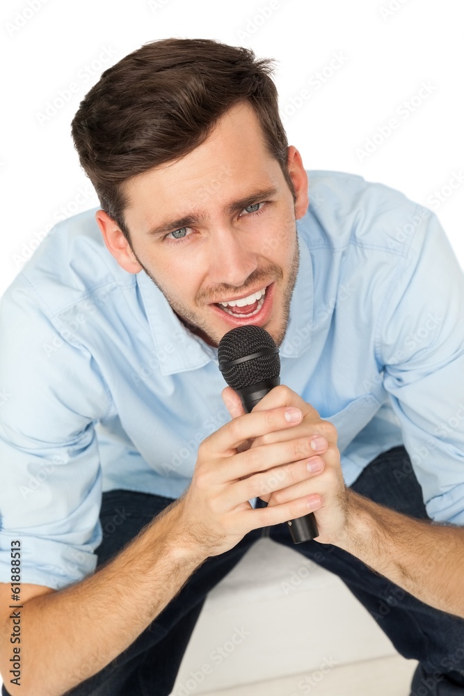Portrait of a young man singing into microphone Portrait of a young man singing into microphone