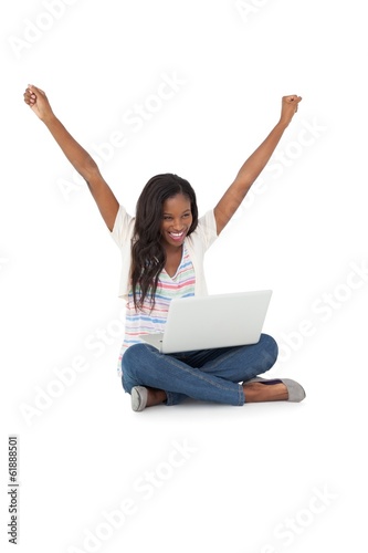 Cheerful young woman with laptop raising hands © WavebreakMediaMicro