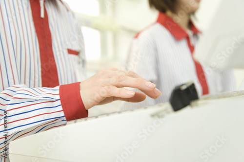 hand of convenience store salesclerk typing cash register