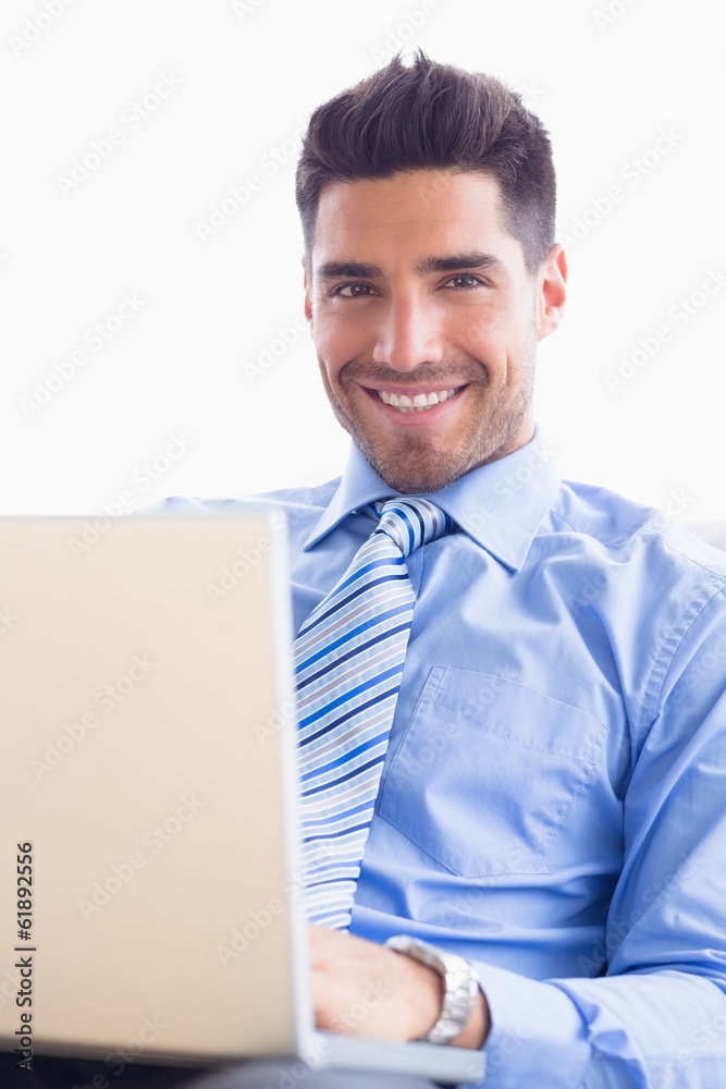 Happy businessman on couch using his laptop Happy businessman on couch using his laptop