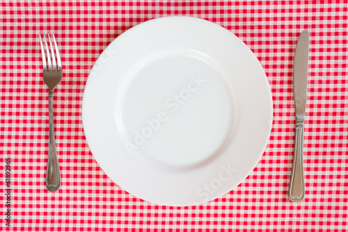 Fork Knife and Plate isolated on a red table cloth