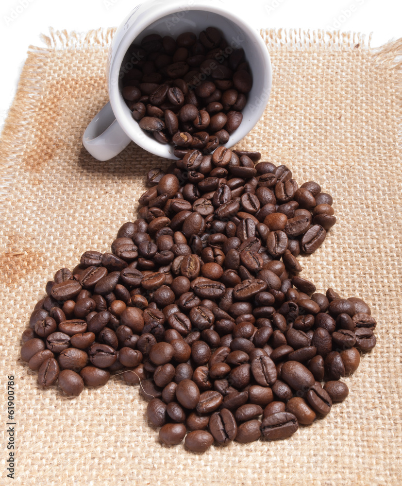 Fototapeta premium white cup with coffee beans on burlap background.