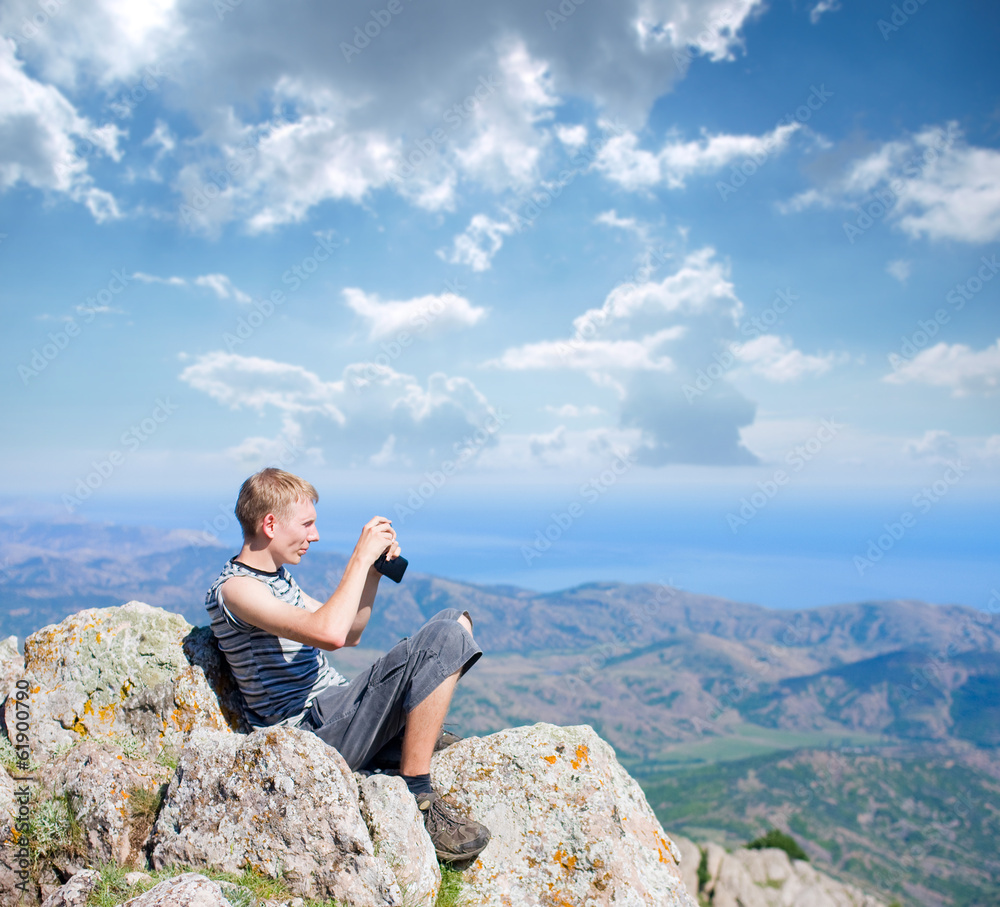 tourist on top of a mountain takes a snapshot of the nature