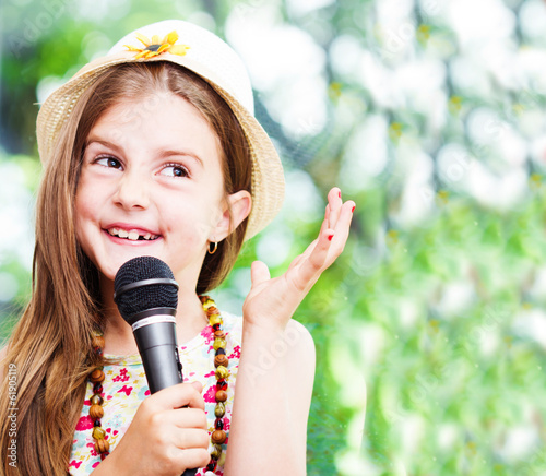pretty little girl with the microphone in her hands - outdoor