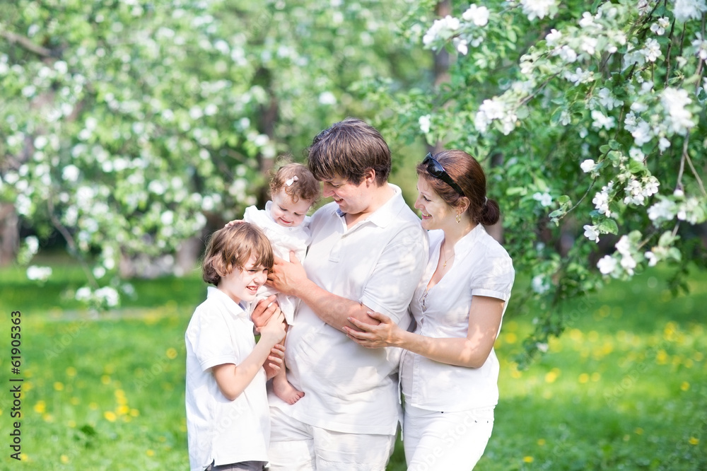 Young family in a beautiful apple tree garden Young family in a beautiful apple tree garden