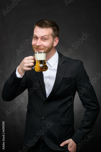 happy man in black suit holding beer mug