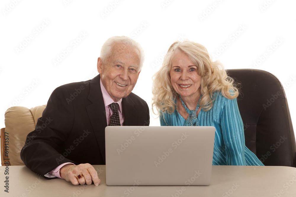 elderly couple laptop both looking smiling