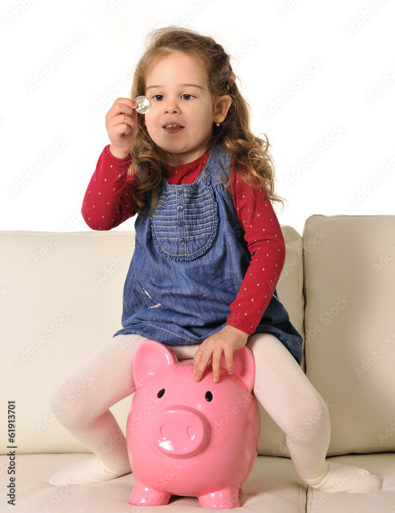 Happy Cute little girl sitting on huge piggy bank inserting Coin Stock ...
