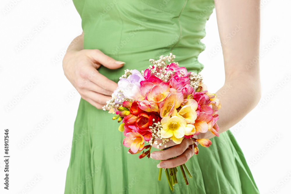 Young woman in green dress holding bouquet of colorful freesia