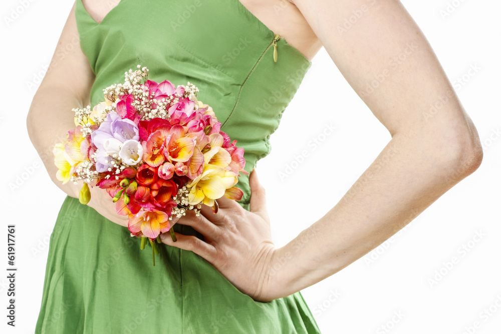 Young woman in green dress holding bouquet of colorful freesia