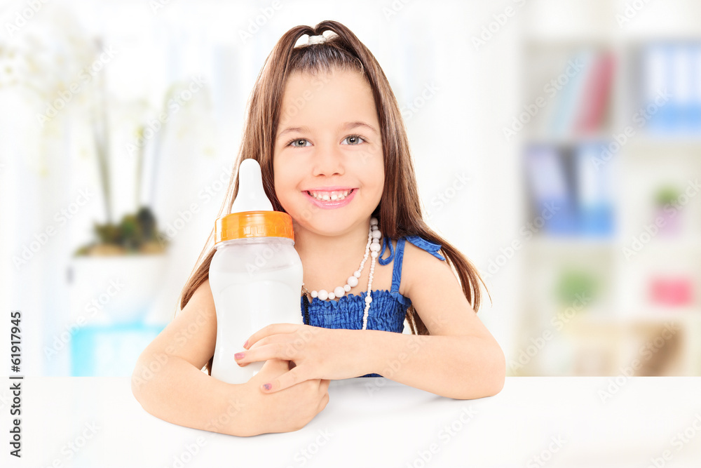 Fashionable little girl holding a baby bottle full of milk Fashionable little girl holding a baby bottle full of milk