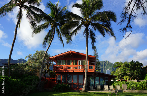 Red Two Story Beach House with tall coconut trees