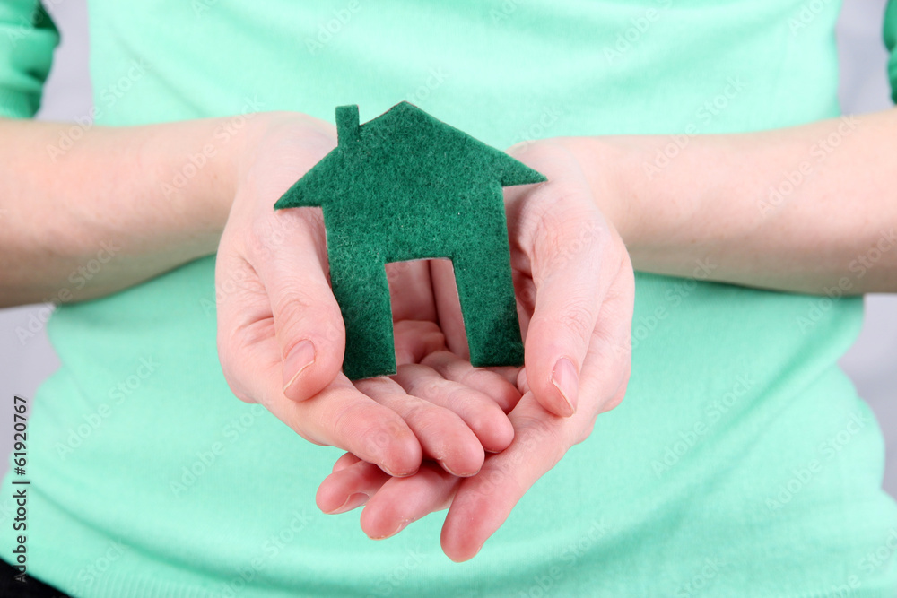 Little paper house in hand close-up, on light background Little paper house in hand close-up, on light background