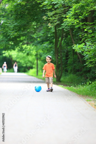 Boy kicks the ball in park outdoors