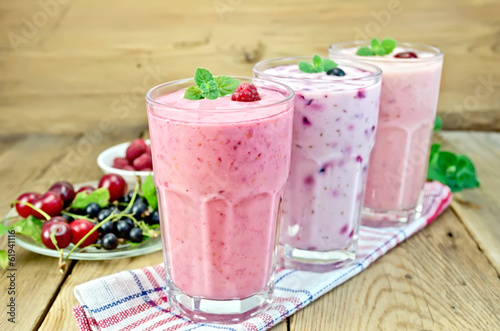 Milkshakes with berries in glass on board