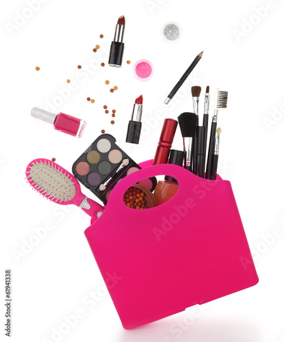 Pink shopping bag with various cosmetics isolated on white