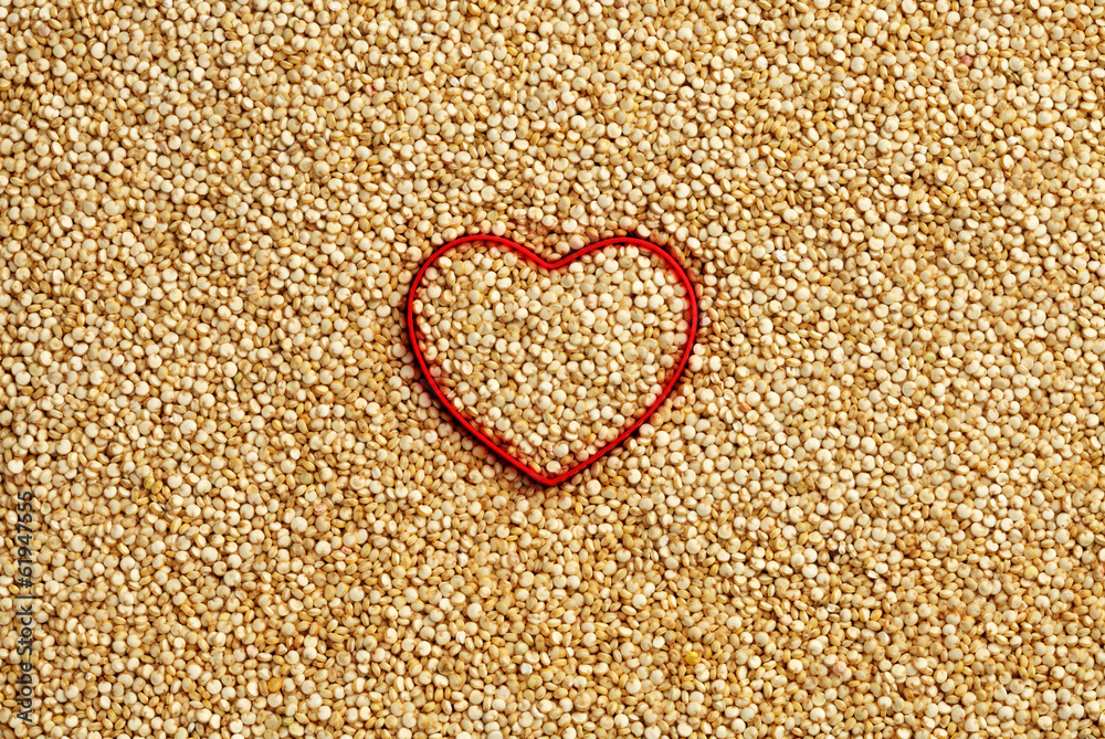 Red heart shape on uncooked quinoa background Red heart shape on uncooked quinoa background