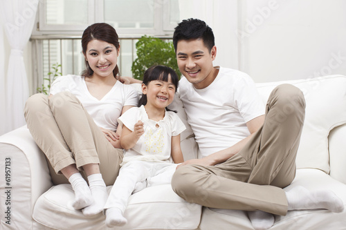 .Young family sitting in couch.