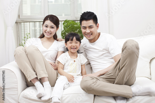 .Young family sitting in couch.