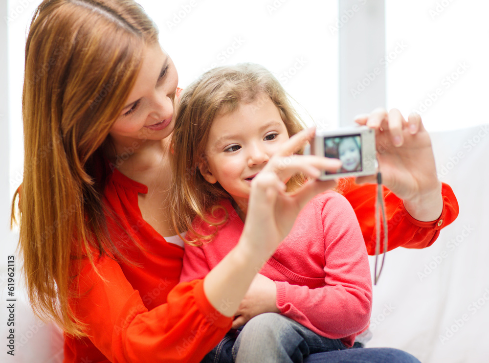 smiling mother and daughter taking picture smiling mother and daughter taking picture