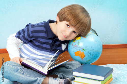 Small boy sit with books and globe