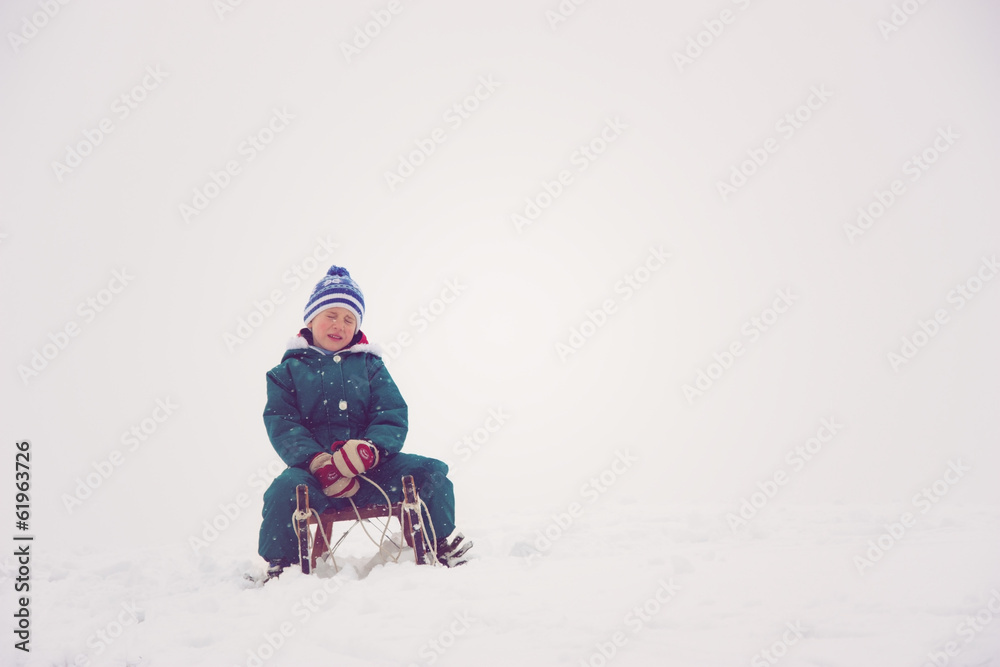 Child siting on his sleigh Child siting on his sleigh