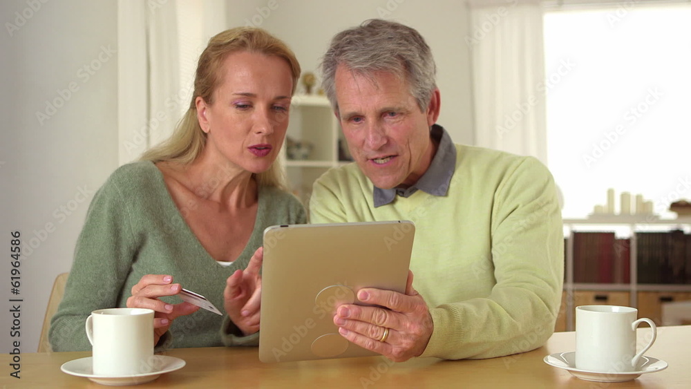 Senior couple using tablet at desk Senior couple using tablet at desk