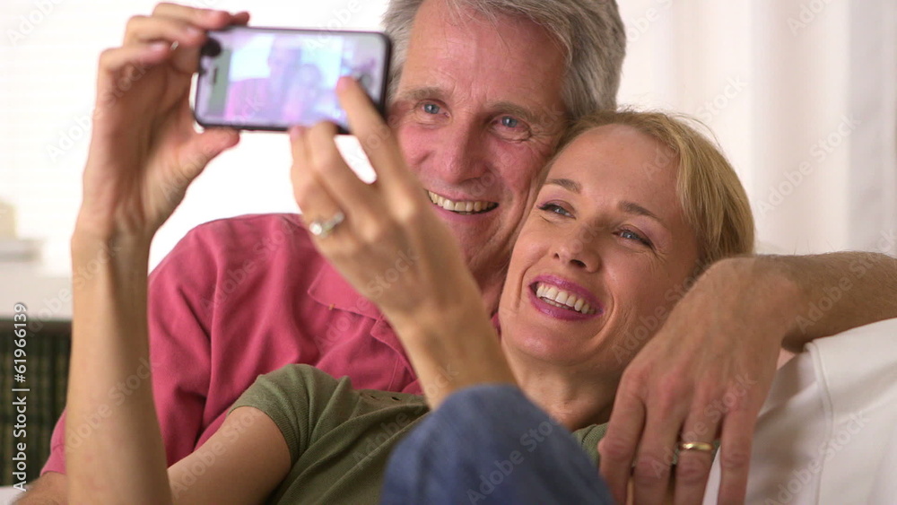 Cute senior couple taking photos on smartphone Cute senior couple taking photos on smartphone