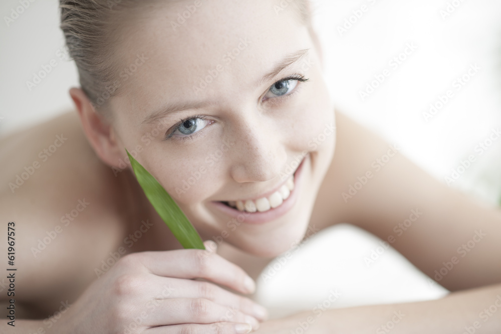 portrait of a beautiful young woman holding a bamboo leaf near h portrait of a beautiful young woman holding a bamboo leaf near h