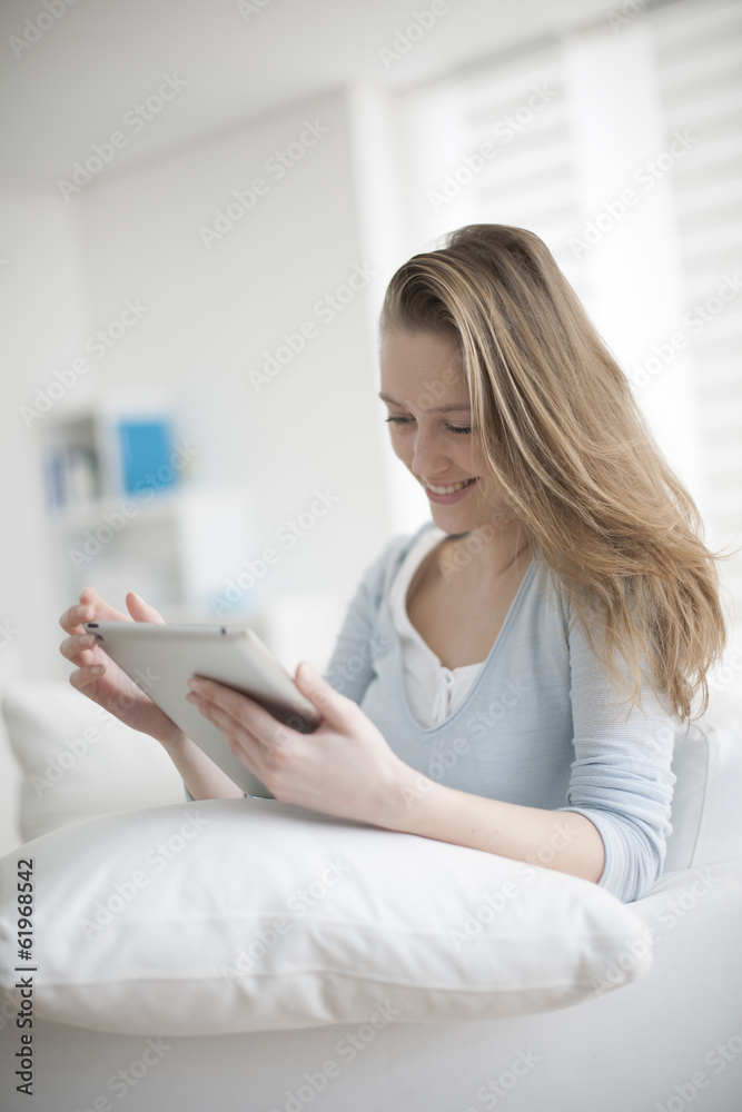 handsome young woman using digital tablet in her couch handsome young woman using digital tablet in her couch