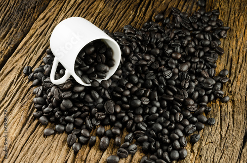 Coffee beans and cup on wooden background