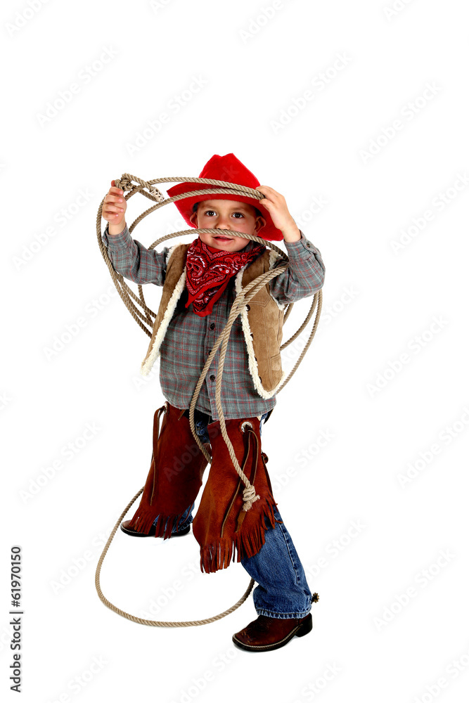 Adorable young cowboy wearing chaps, boots, and hat playing with