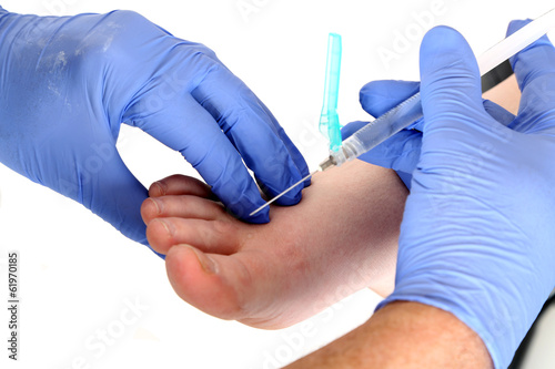 close up of a doctor giving a shot in the foot