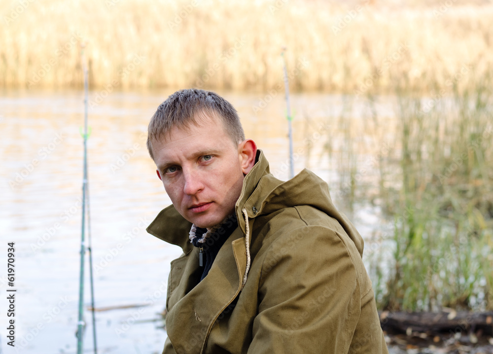 Middle-aged fisherman fishing at a lake Middle-aged fisherman fishing at a lake