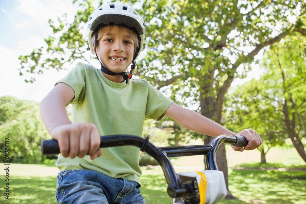 Smiling boy riding bicycle at park